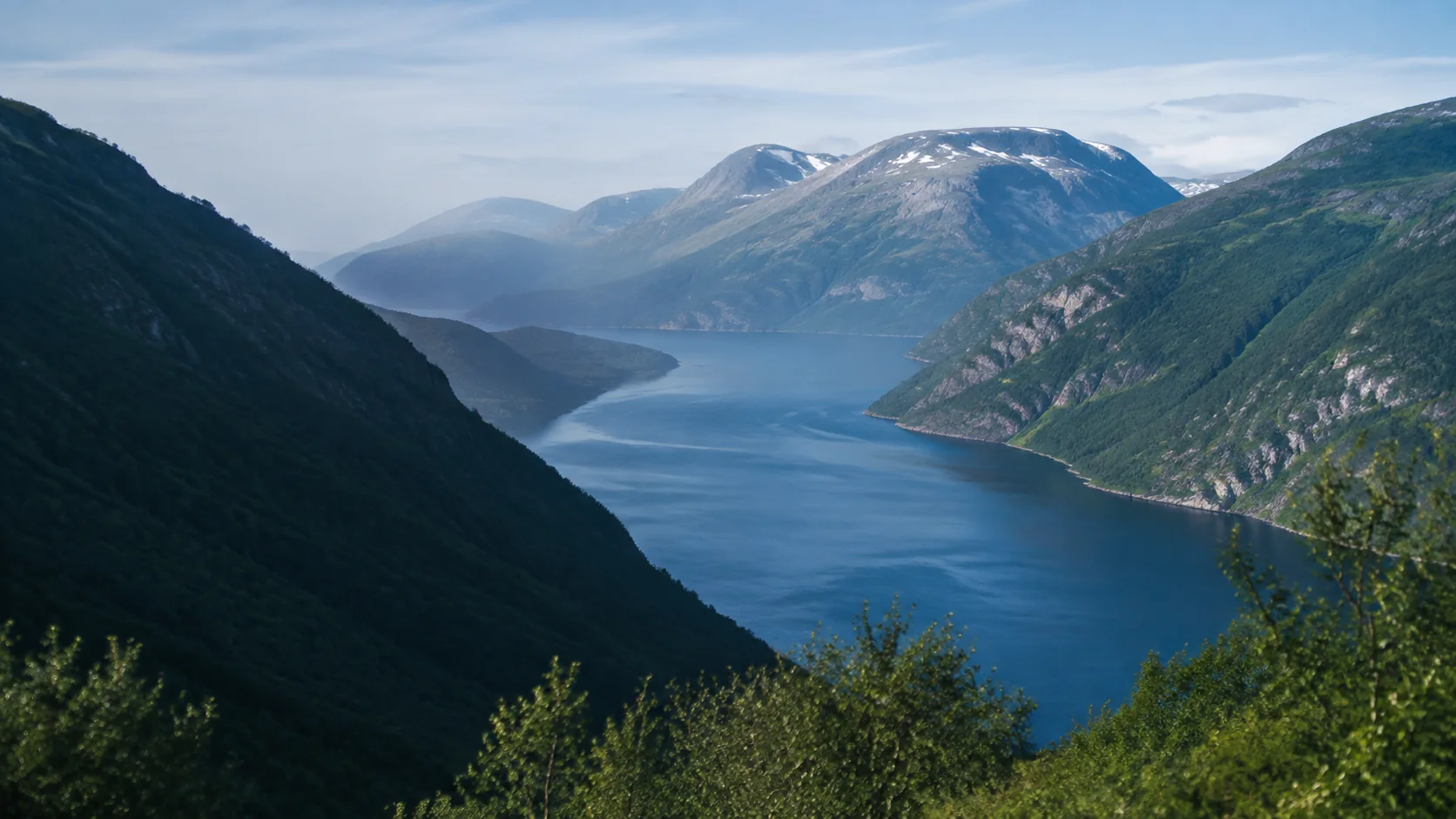 Norwegian fjord between steep green mountains